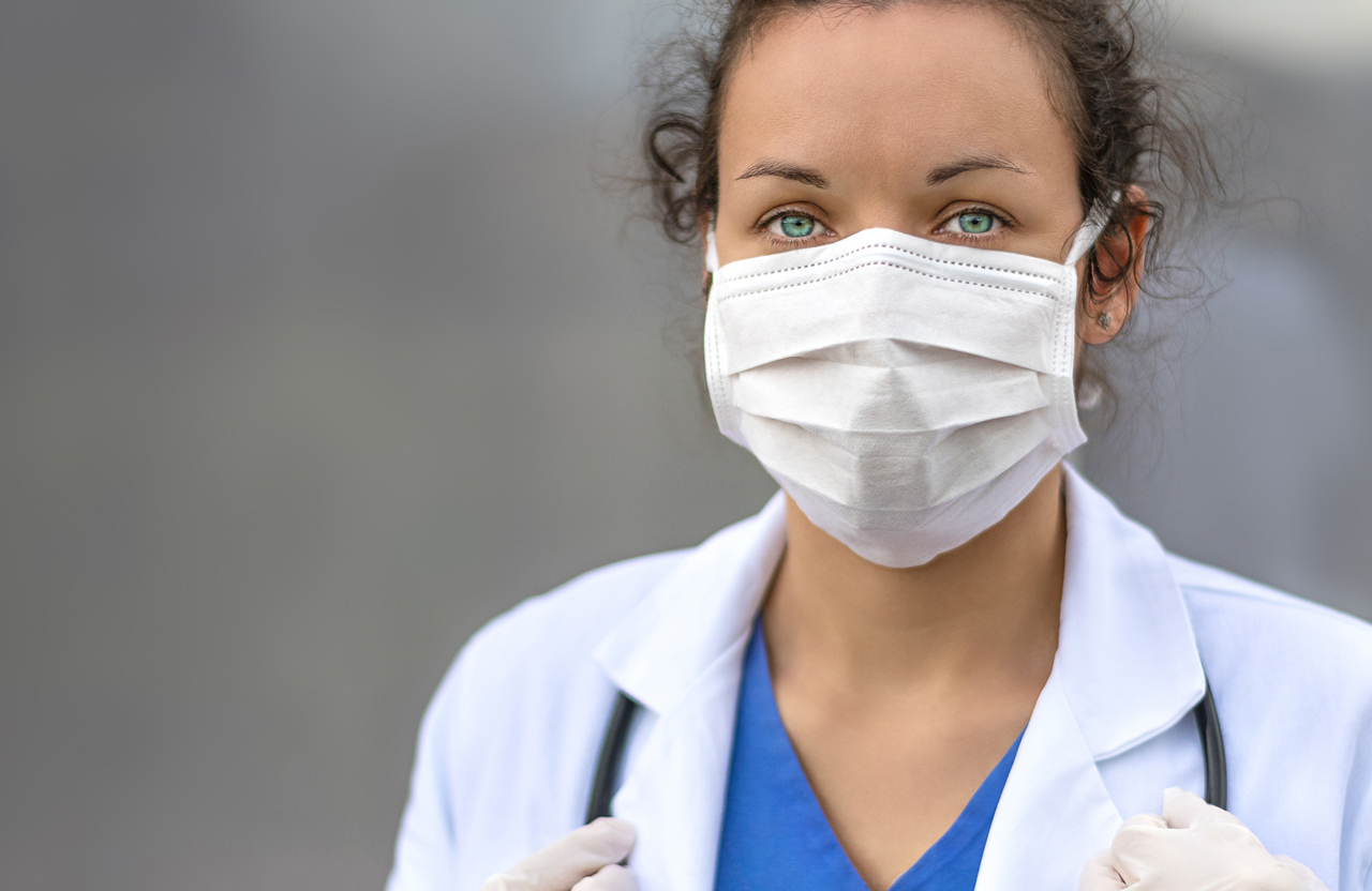 Female pharmacist wearing a medical facemask.