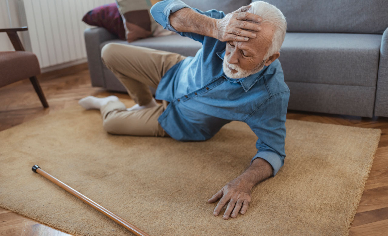 Elderly white man on the ground after a fall, a cane is nearby