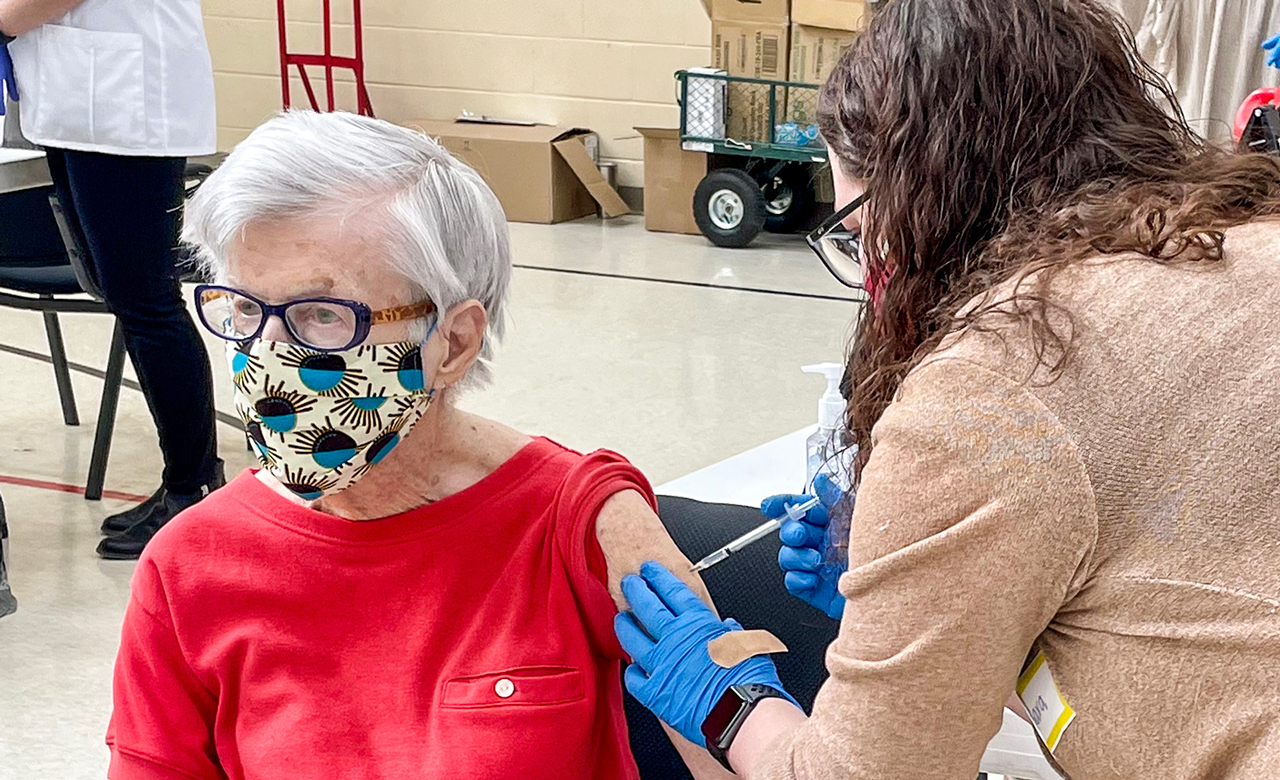 A Pharmacy Tech administers a vaccine.