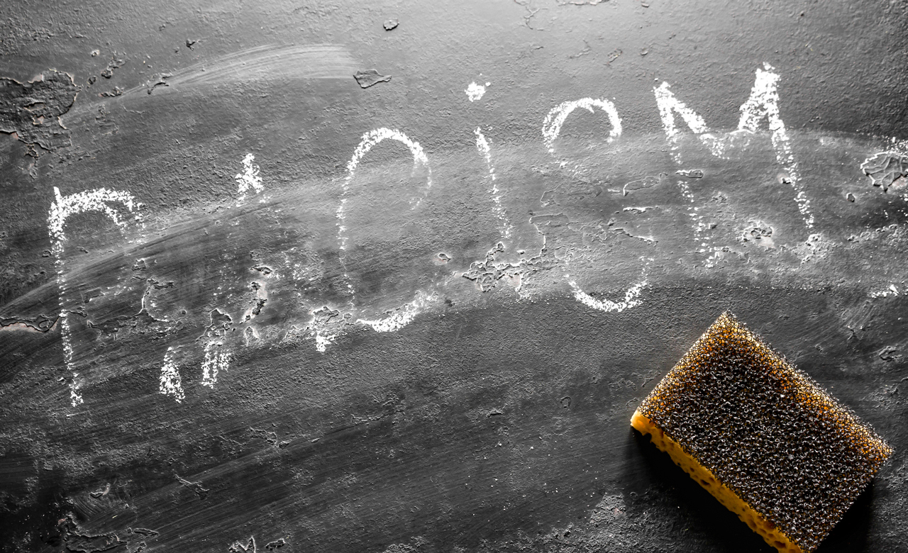 The partly erased word "Racism" written on a chalkboard.