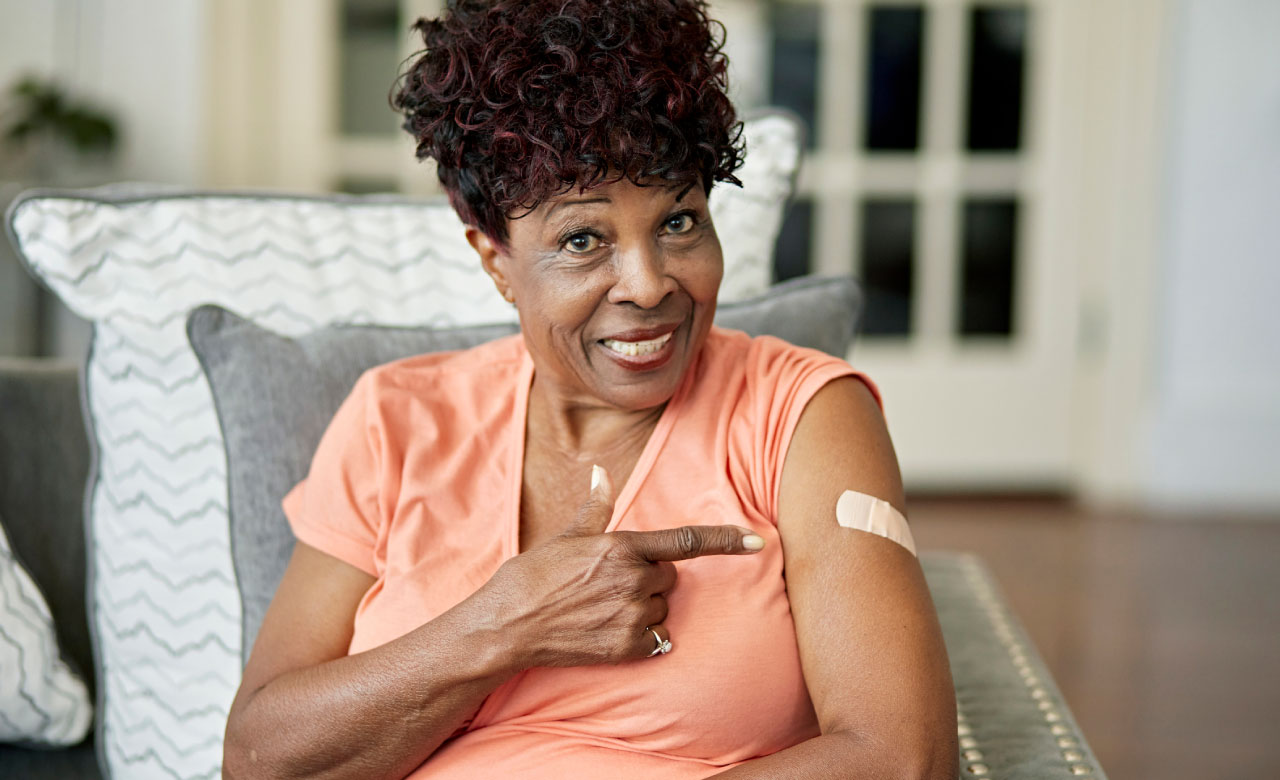 Woman pointing at bandage on her arm